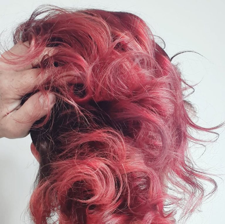 Cabello rizado con coloración roja intensa en Peluquería Ritual.