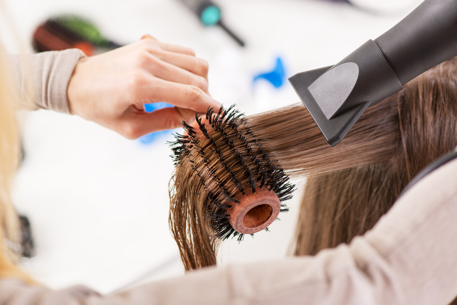 Secado profesional de cabello con un cepillo redondo, destacando los servicios de peluquería y estética en Puerto del Carmen Las Palmas.