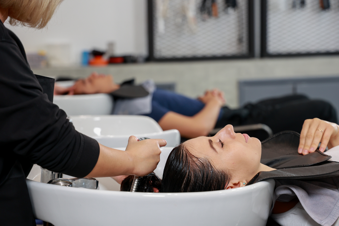 alón con clientes recibiendo servicios de lavado de cabello, ilustrando el ambiente profesional de peluquería y estética en Puerto del Carmen Las Palmas.